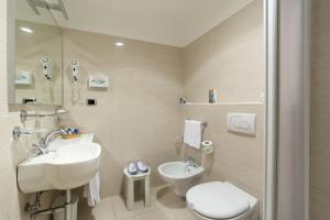 
a bathroom with a toilet, sink, and mirror at Hotel Porto Roca in Monterosso al Mare
