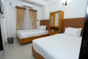 una camera d'albergo con due letti e uno specchio di Hotel Blue Castle a Dhaka