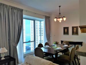 a living room with a table and a large window at Luton Vacation Homes -Sea View Marina Promenade in Dubai