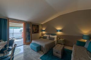 a bedroom with a bed and a living room at Hotel Porto Roca in Monterosso al Mare