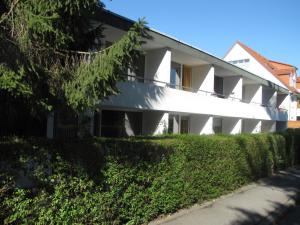 a white building with a hedge in front of it at Appartementhaus Martel - Adults Only in Travemünde
