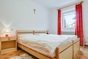 um quarto com uma cama grande e uma janela em Appartamento Fraine em Pozza di Fassa