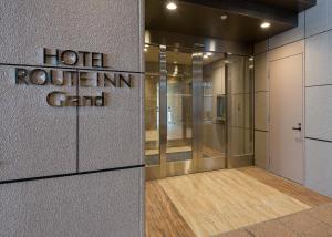 une chambre d'hôtel avec un panneau d'auberge sur un mur dans l'établissement Hotel Route Inn Grand Asahikawa Ekimae, à Asahikawa