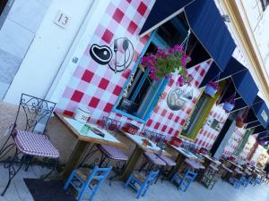 a group of tables and chairs in front of a building at Apartments STAR with Pool in Biograd na Moru