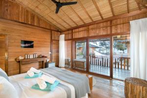 a bedroom with a bed with towels on it at Kuda Laut Boutique Dive Resort in Bunaken