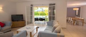 a living room with a couch and a television and a table at Lagrange Vacances - Le Clos Savornin in Saint-Saturnin-lès-Apt