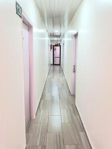 een lange hal met witte muren en een tegelvloer bij Hotel du Golfe de Guinée in Conakry +1 foto