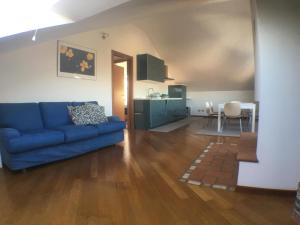 un soggiorno con divano blu e una cucina di Casa Vacanze Magnolia a Borgo Ticino