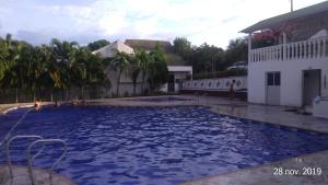 a large pool of blue water in a courtyard at Full House in Girardot
