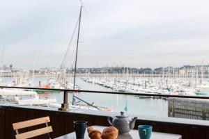 - une table avec vue sur un port de plaisance avec des bateaux dans l'établissement La Cabine by Cocoonr, à Saint-Malo