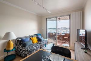 a living room with a couch and a table at La Cabine by Cocoonr in Saint Malo