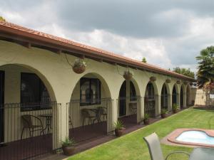 a courtyard of a house with chairs and plants at Captains Quarters Motor Inn in Cambridge