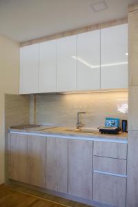 a kitchen with white cabinets and a sink at Apartman Vip Aleksa Zlatibor Centar in Zlatibor