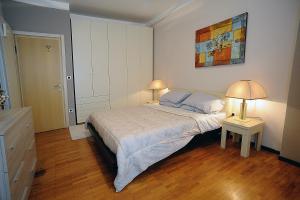 サンレモにあるCasa Vacanze Helsinoreのベッドルーム1室(ランプ2つ、壁に絵画付)