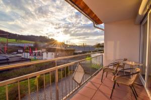 einen Balkon mit Stühlen und Blick auf einen Bahnhof in der Unterkunft NringRooms Exit-Breidscheid in Adenau