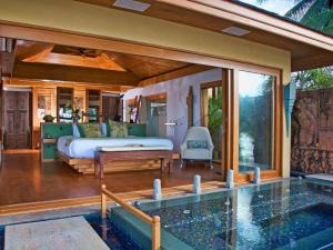 バンラック・ビーチにあるUpni Duniya - Luxury, Beachfront 9-suites Villaのベッドとプールのある寝室