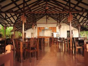 a restaurant with wooden tables and chairs and a kitchen at Redang Paradise Resort in Redang Island