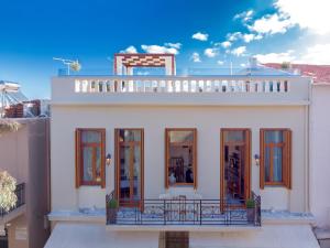a white house with a balcony on top of it at StefaniHome in Rethymno Town