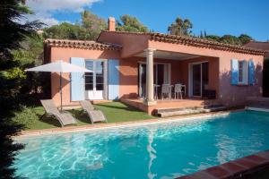 a villa with a swimming pool in front of a house at Résidence Lagrange Vacances Le Domaine de l'Eilen in Cavalaire-sur-Mer