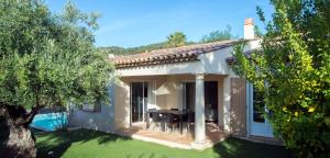 een wit huis met een tafel en een tuin bij Lagrange Vacances - Le Domaine de l'Eilen in Cavalaire-sur-Mer