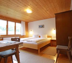 a bedroom with a bed and a desk with a desk at Haus Annelies in Au im Bregenzerwald