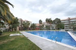 a large swimming pool with palm trees and buildings at For a Stay Aqquaria Deluxe in Salou