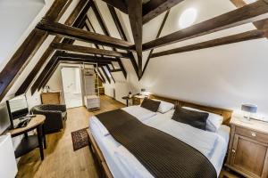 - une chambre avec un grand lit dans une pièce dotée de plafonds en bois dans l'établissement Archibald At the Charles Bridge, à Prague