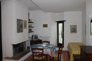 a room with a table and a bed and a fireplace at Appartamento La Perla a soli 100m dal mare a Marina di Castagneto in Marina di Castagneto Carducci