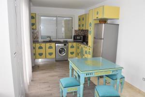a kitchen with a blue table and a refrigerator at Arabesque Style - 2 appartements in Kelibia