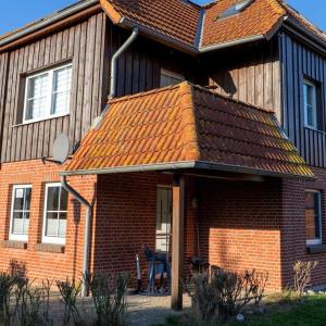 a brick house with an orange tile roof at Ferienwohnung-Kuestennaehe in Wenkendorf