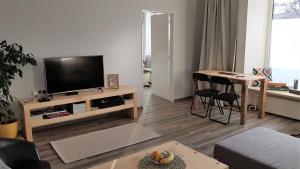 a living room with a television and a table and chairs at pAt - a spacious place near the station and center in Spišská Nová Ves