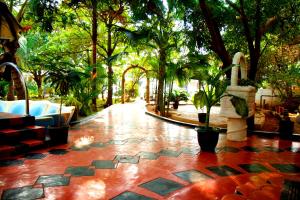 patio z drzewami i czerwoną podłogą wyłożoną kafelkami w obiekcie Tilko City Hotel Jaffna w mieście Dżafna