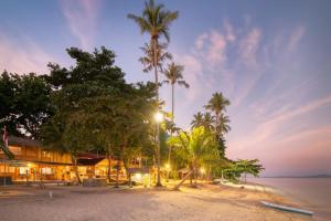 un complexe avec des palmiers sur une plage la nuit dans l'établissement Kuda Laut Boutique Dive Resort, à Bunaken