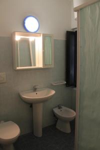 a bathroom with a sink and a toilet and a mirror at Appartamento La Perla a soli 100m dal mare a Marina di Castagneto in Marina di Castagneto Carducci
