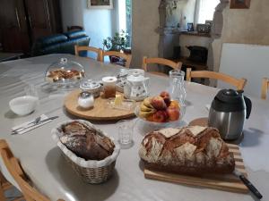 a table with a loaf of bread and fruit on it at Manoir de Questinguy in Allineuc