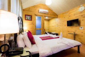 a bedroom with a bed in a room with wooden walls at Bodh Valley Resort in Igatpuri