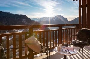 a balcony with chairs and a table with a view of mountains at TERRESENS - Le Saphir in Vaujany