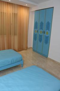 a bedroom with a bed and a closet with a blue bed at Arabesque Style - 2 appartements in Kelibia
