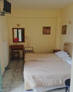 a hotel room with two beds and a mirror at Ξενοδοχείο "Ηραία" in Iamatikes Piges