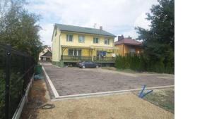 a house with a car parked in a driveway at Pokoje Jasionka Zaczernie in Trzebownisko