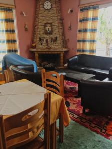 sala de estar con sofá, mesa y reloj en Ξενοδοχείο "Ηραία" en Iamatikes Piges