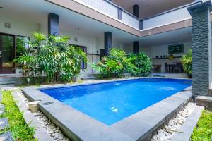 a swimming pool in the backyard of a villa at OYO 2143 Leluhur Bali Apartment in Seminyak
