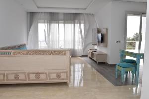 a bedroom with a bed and a desk and a table at Arabesque Style - 2 appartements in Kelibia