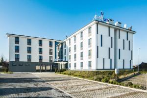 ein großes weißes Gebäude mit einer Straße davor in der Unterkunft Hotel Urbi in Danzig