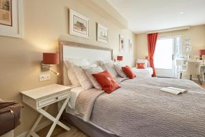a bedroom with a large bed with red pillows at Les Villas d'Arromanches, Teritoria in Arromanches-les-Bains