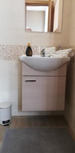 een badkamer met een witte wastafel en een spiegel bij La terrazza Ursino in Catania