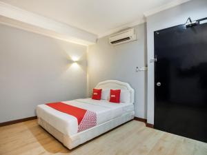 a bedroom with a bed with two red pillows at OYO 89568 Mangrove Hotel in Tawau