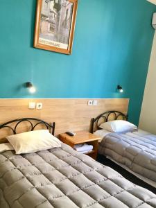 two beds in a room with blue walls at Hotel Kastoria in Thessaloniki