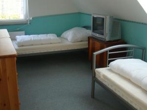 um quarto com duas camas e uma televisão numa secretária em Ferienhaus zu Wohlsborn em Wohlsborn