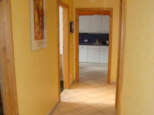 un pasillo que conduce a una cocina con paredes amarillas en Ferienhaus zu Wohlsborn en Wohlsborn